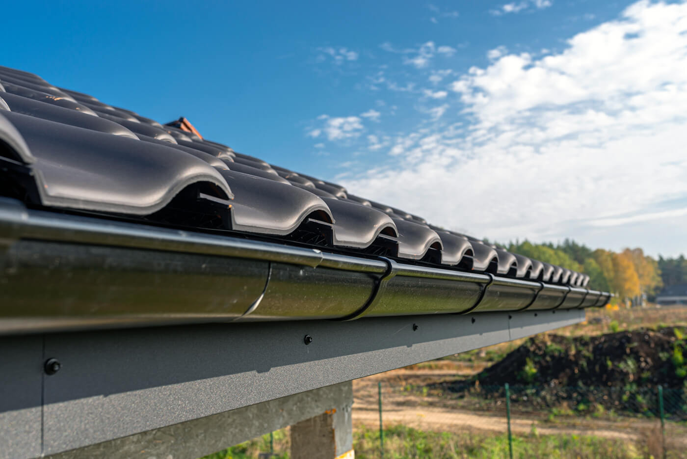 Close up of gutter installation on black roof in Overland Park