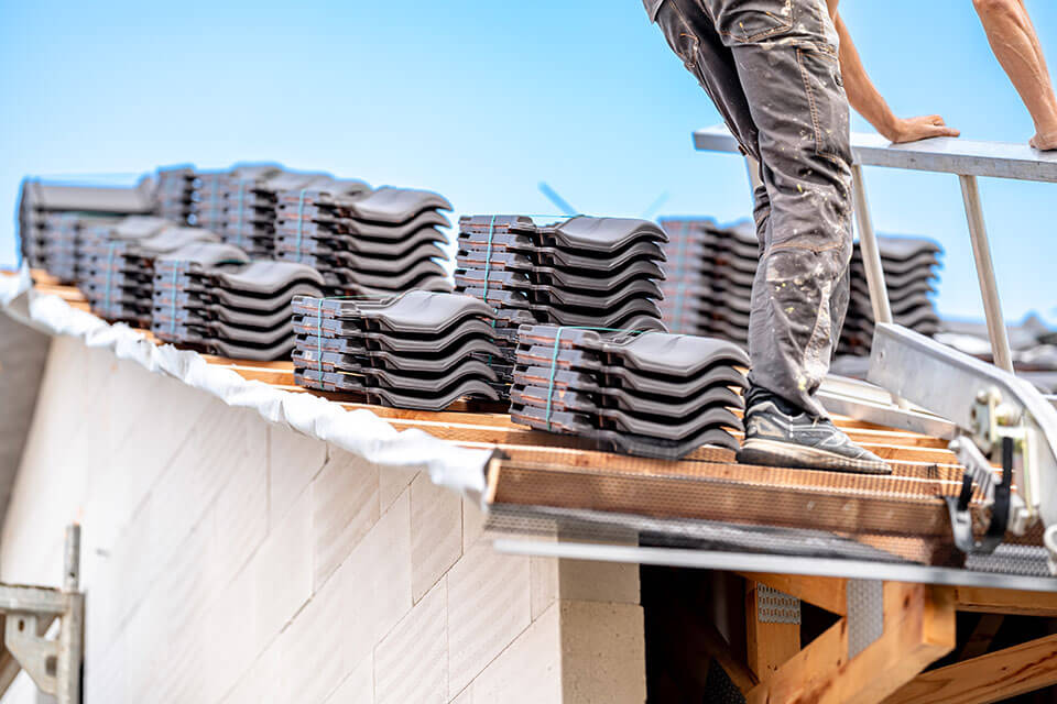 Worker preparing shingles for residential roof repair in Kansas City