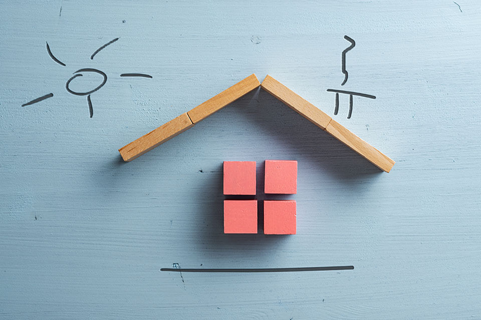 A model of a house that needs spring roof maintenance made with blocks.